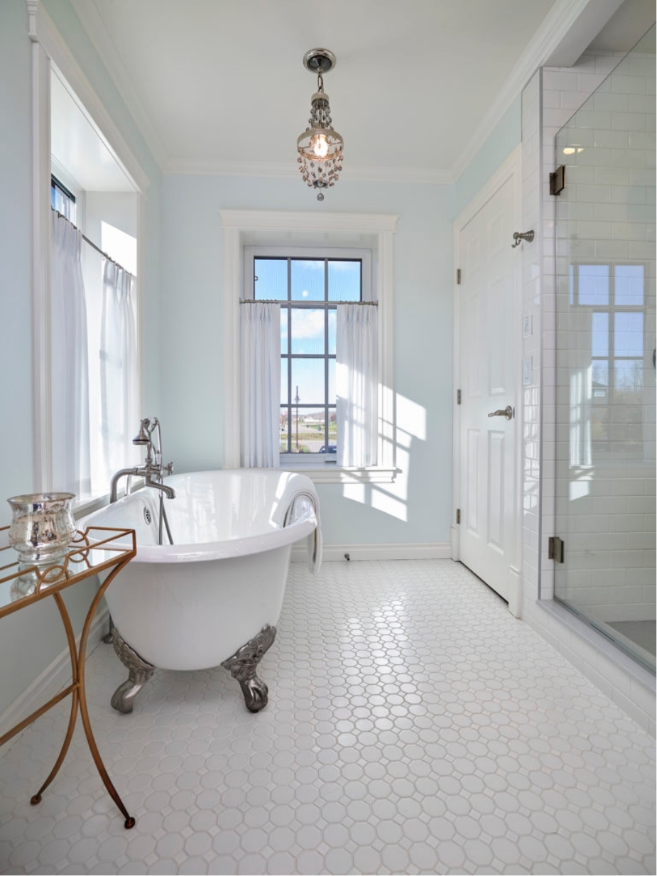 Claw foot tub in a modern farmhouse bathroom custom luxury home by Effect Home Builders